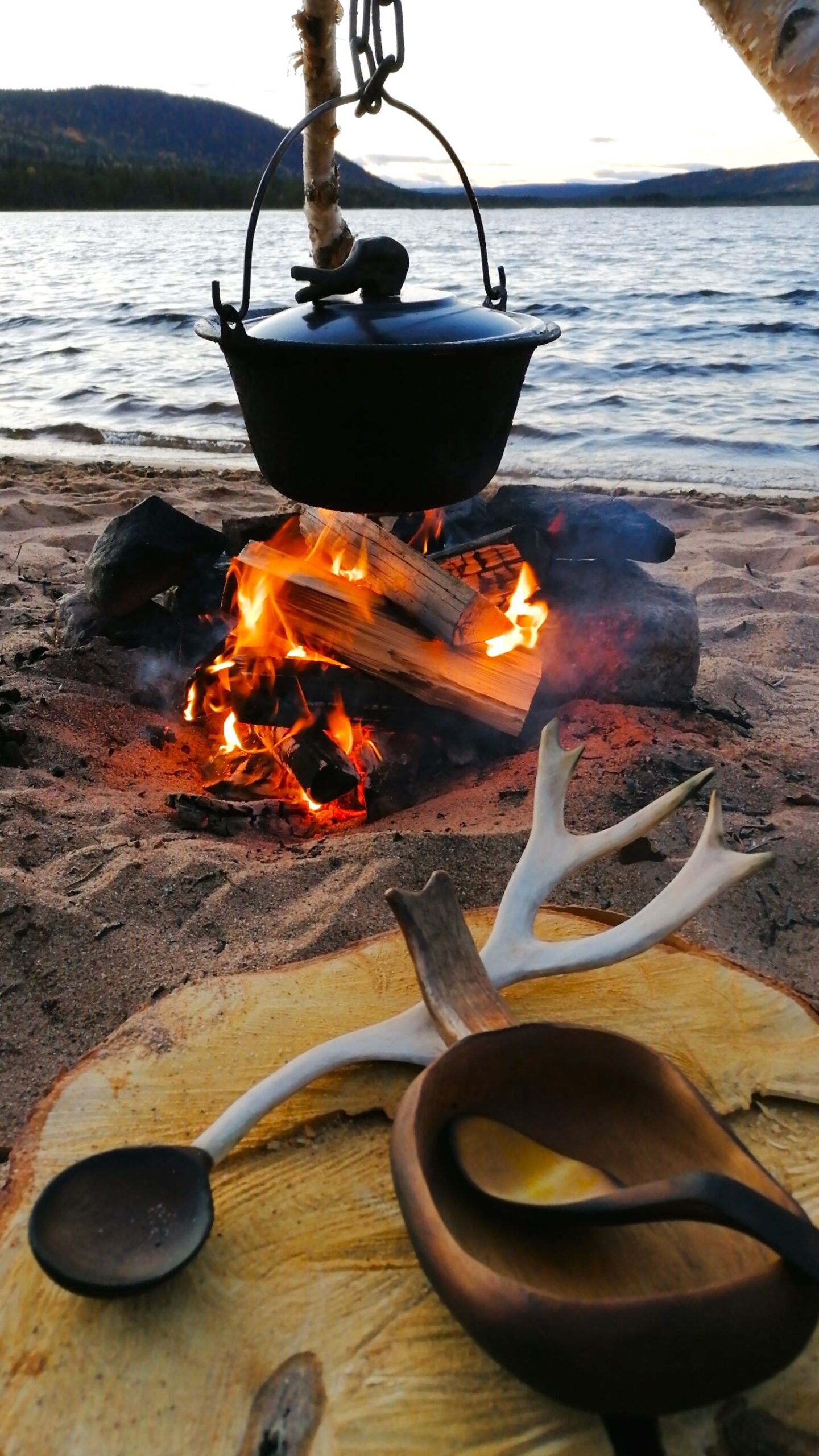 wooden kuksa and outdoor cooking in sweden by a campfire