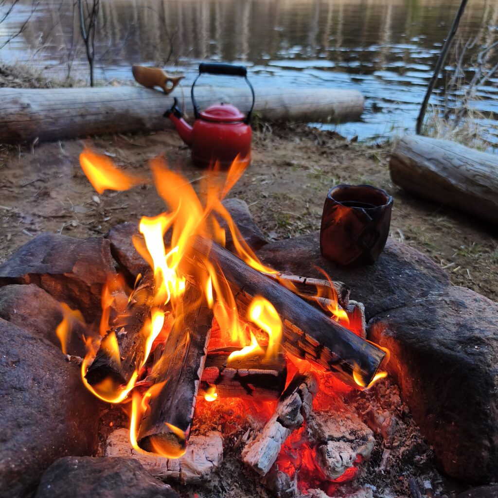 campfire in northern sweden with a kuksa cup handmade by witaberget