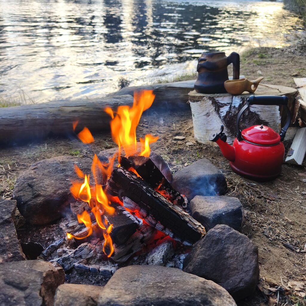 campfire in northern sweden with a kuksa cup handmade by witaberget